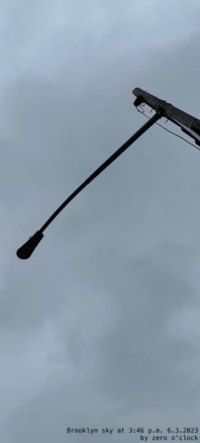 Two streetlights against a gray sky with text at the bottom.