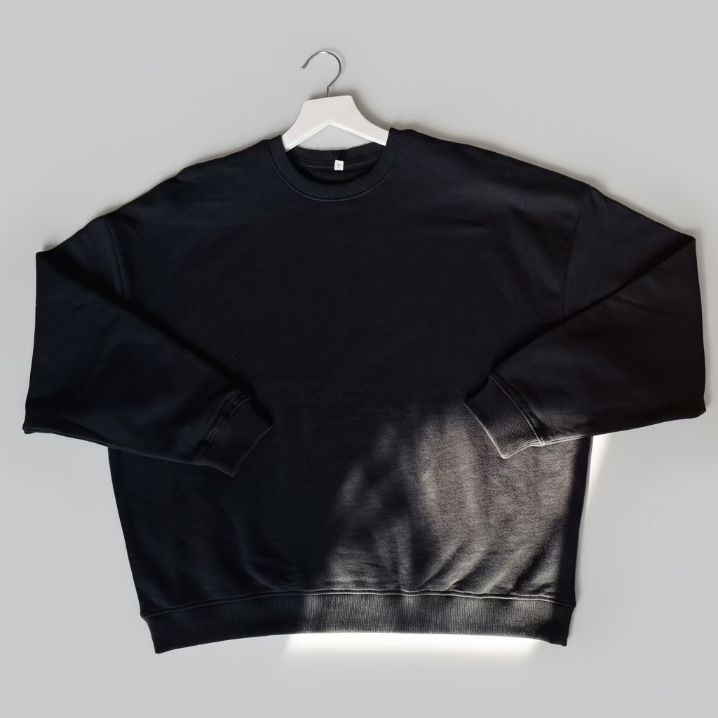 Black sweatshirt on a white hanger against a gray background
