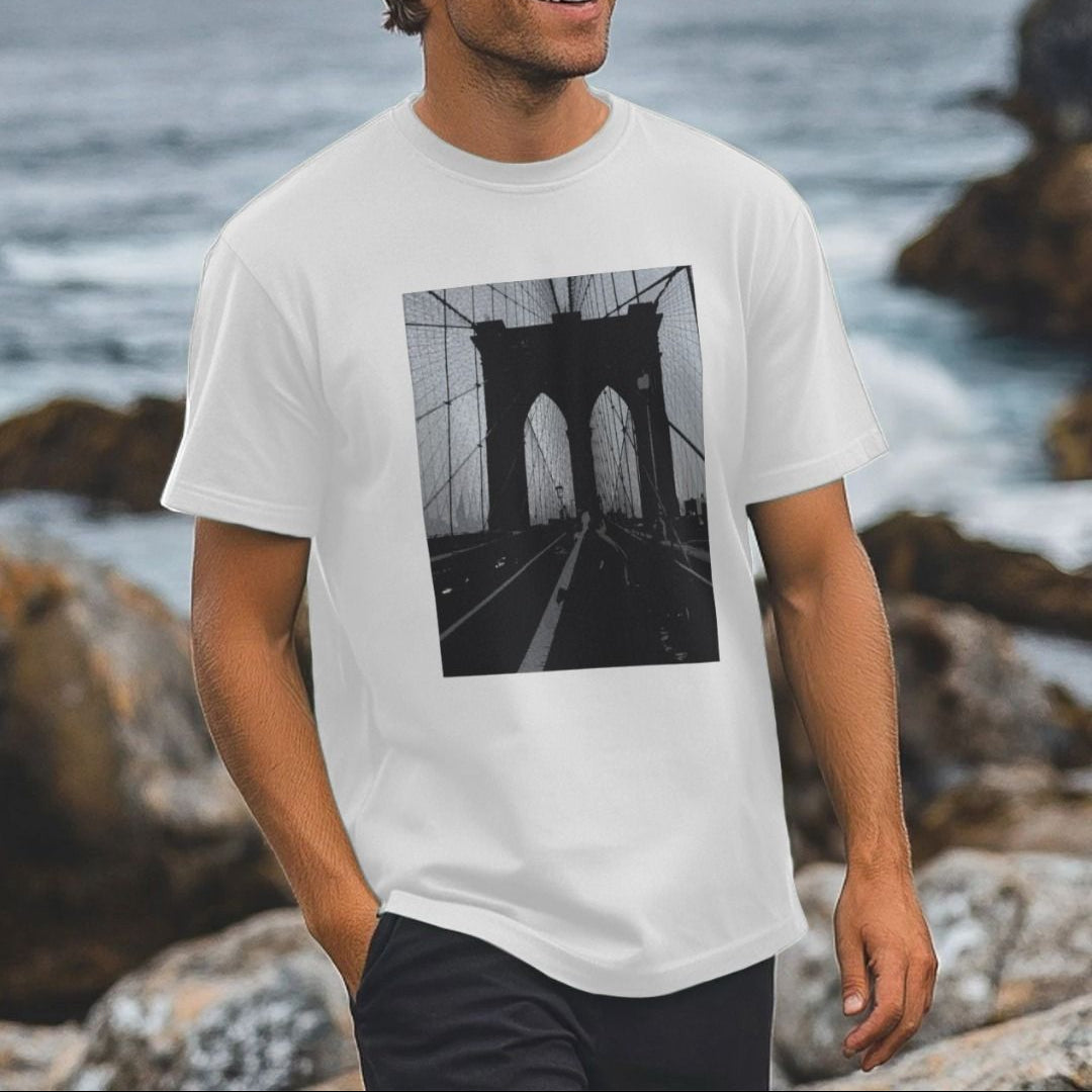 Person wearing a white t-shirt with a black and white graphic of the Brooklyn Bridge