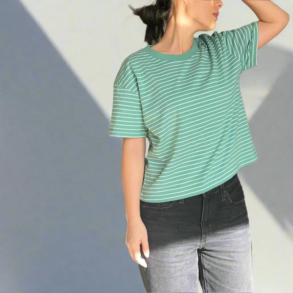 Person wearing a green and white striped tshirt against a plain background