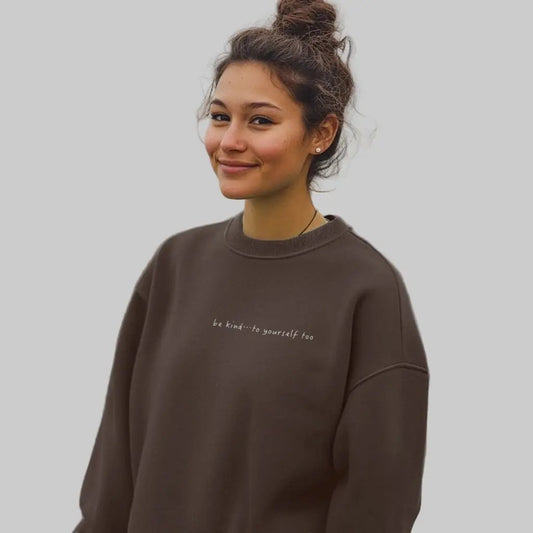 Female model wearing a chocolate brown sweatshirt with text printed on the chest