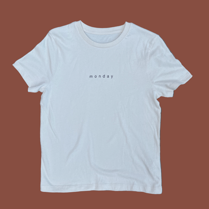 White t-shirt with 'monday' text on a gray background