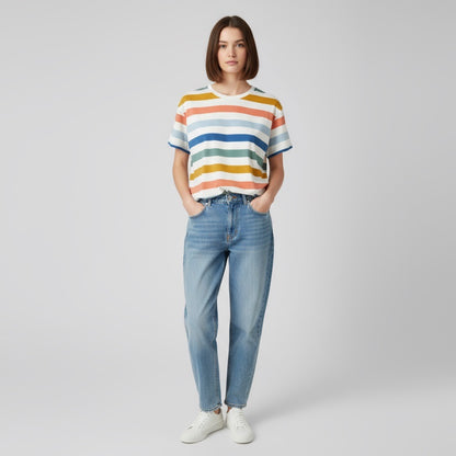Person wearing a striped boxy tshirt and jeans on a plain background