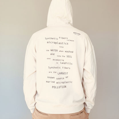 Person wearing a hoodie with environmental message text on a plain background