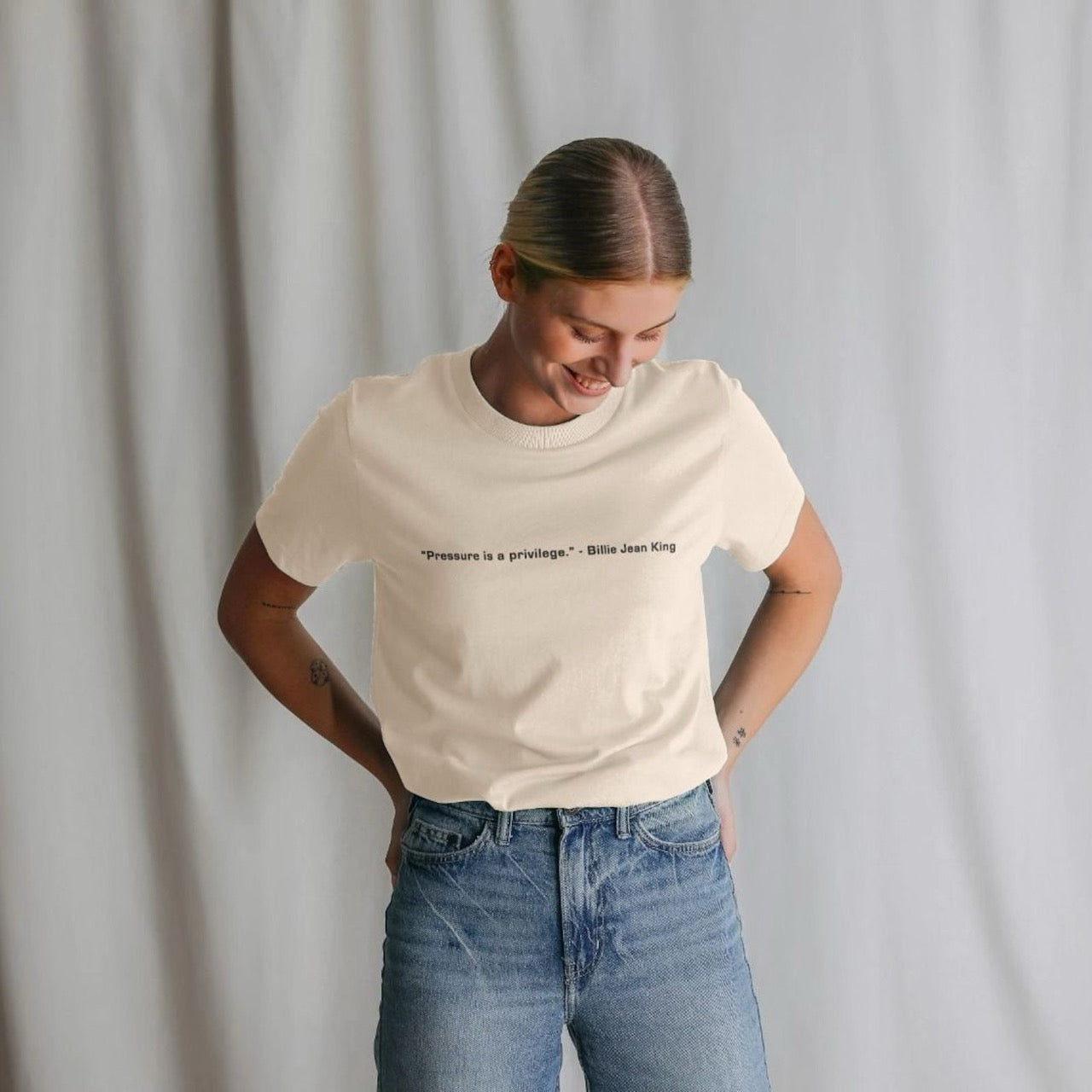 Person wearing a white t-shirt with text and blue jeans