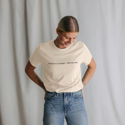 Person wearing a white t-shirt with text and blue jeans