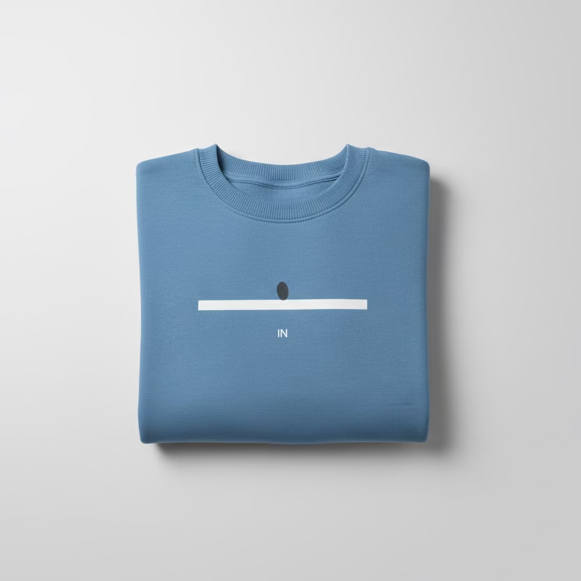 Folded blue sweatshirt with a minimalistic design on a light gray background