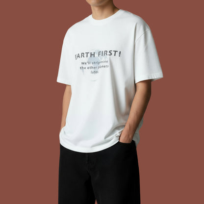 Person wearing a white t-shirt with 'Earth First!' text