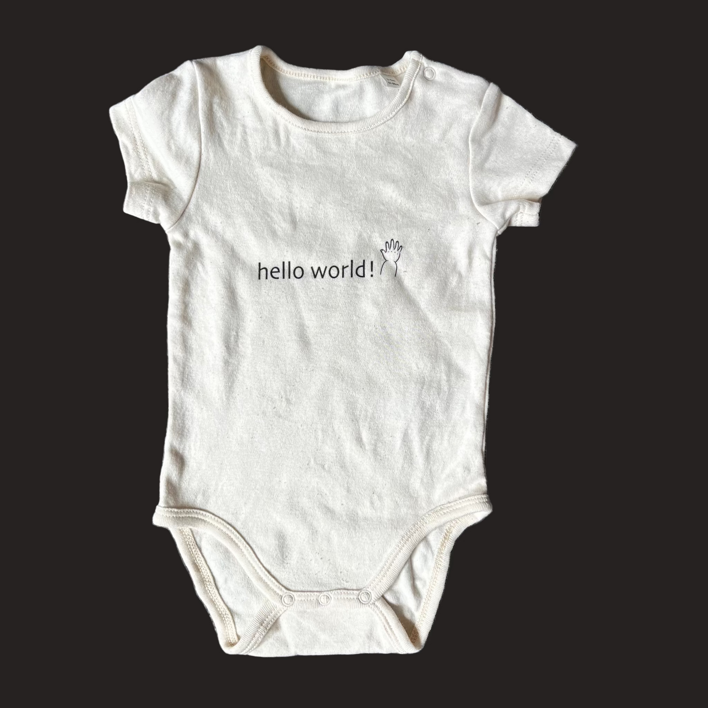 White baby onesie with 'hello world!' text