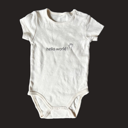White baby onesie with 'hello world!' text