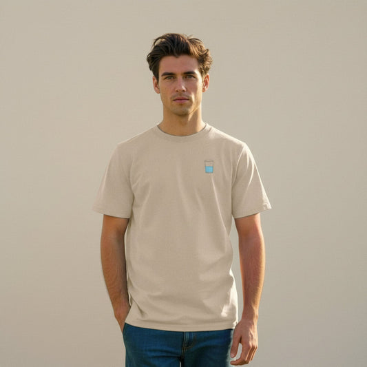 Man wearing a beige t-shirt with a small half full water glass graphic