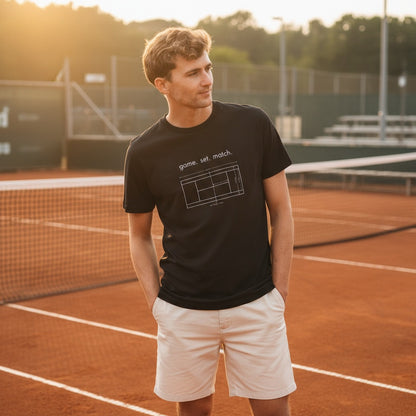 Person wearing a black t-shirt with a tennis court design on a tennis court