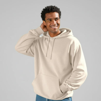Man wearing a oat cream hoodie against a gray background