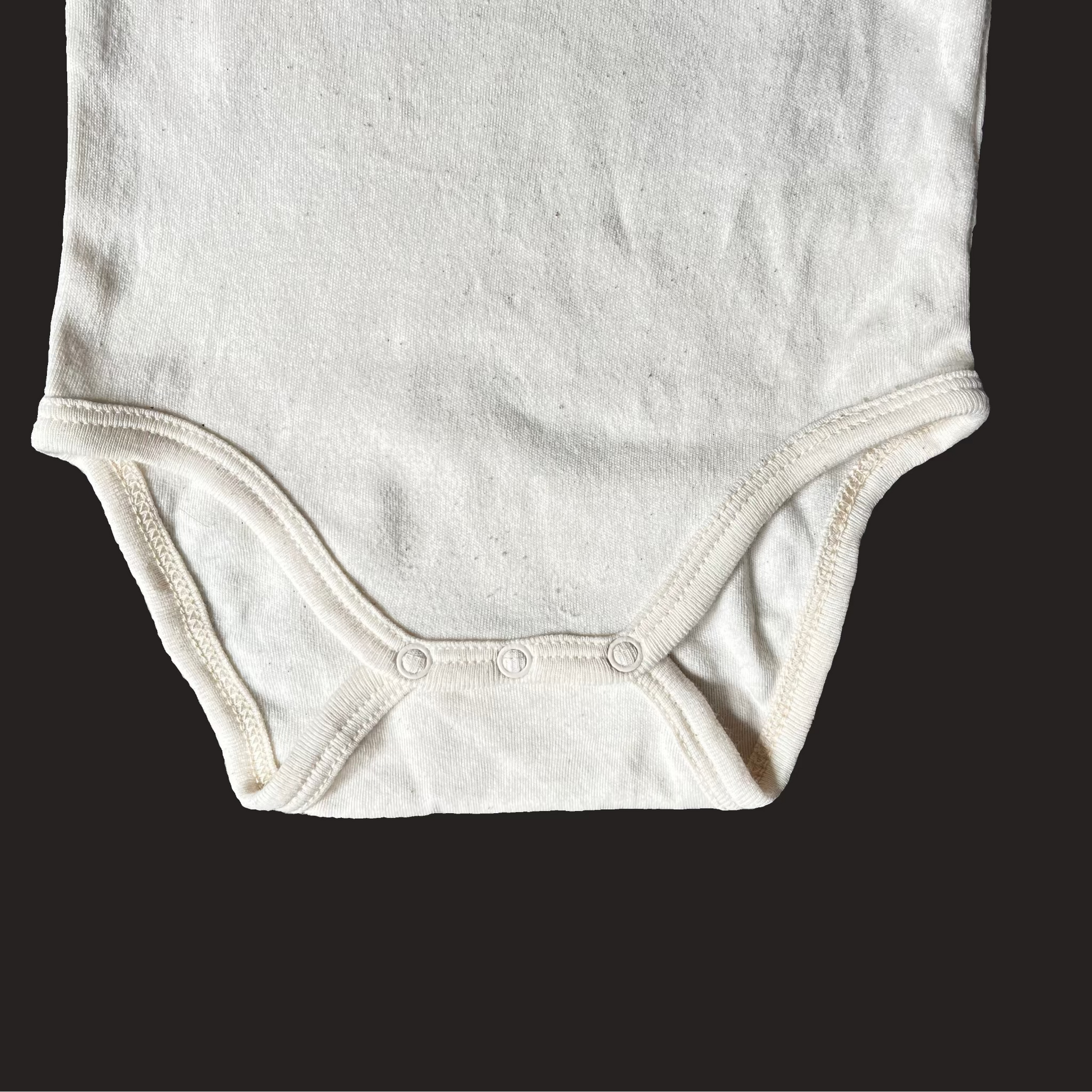 oat cream baby onesie close up