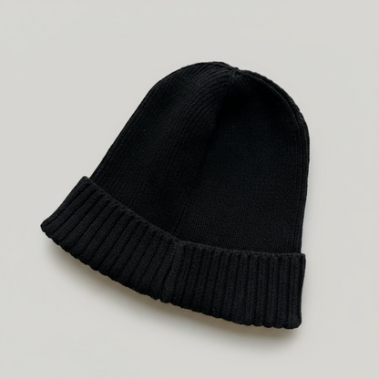 Black knit beanie on a light gray background