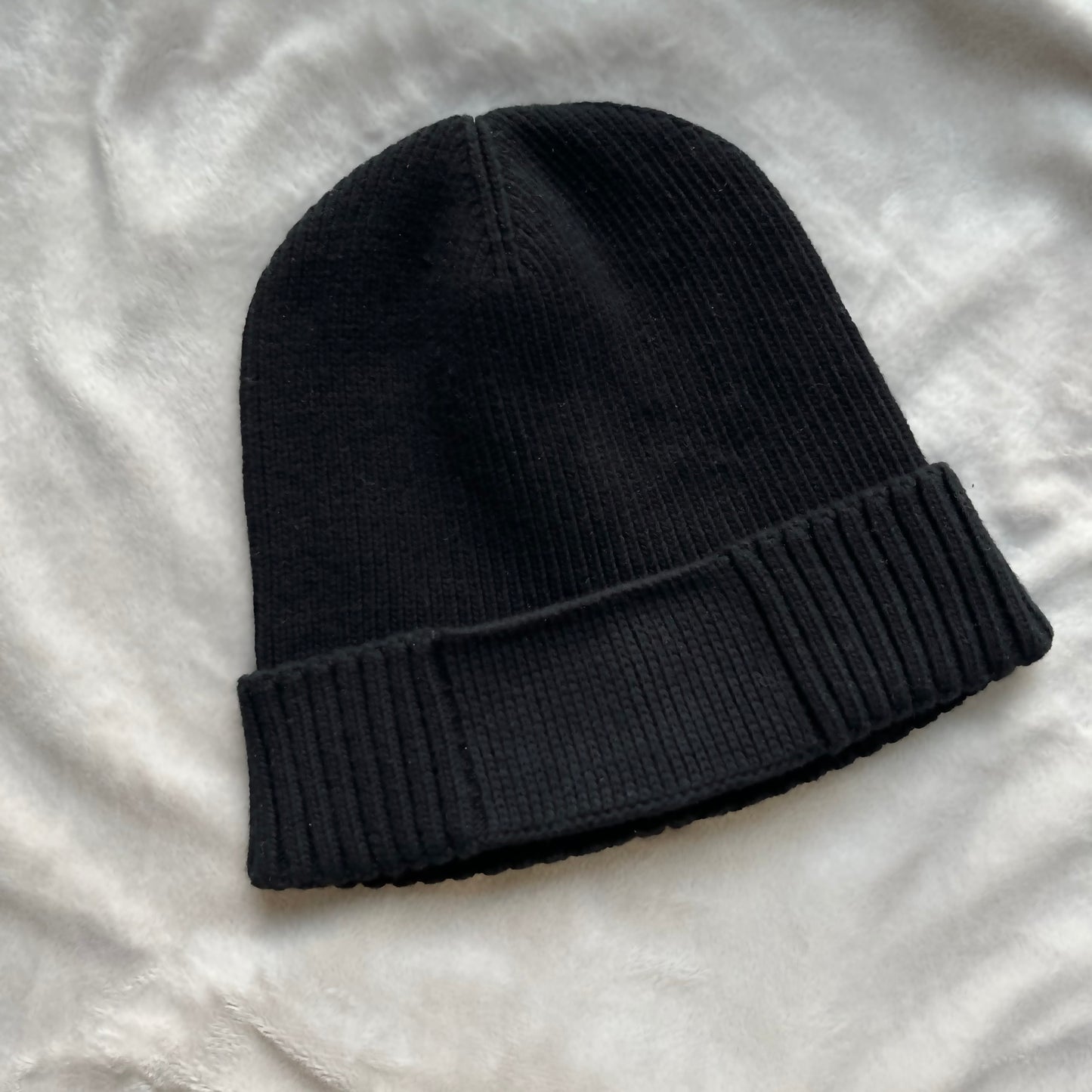 Black knit beanie on a light gray background