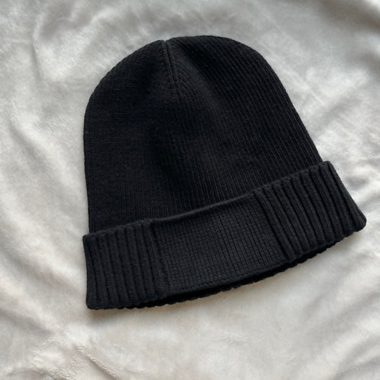 Black knit beanie on a light gray background