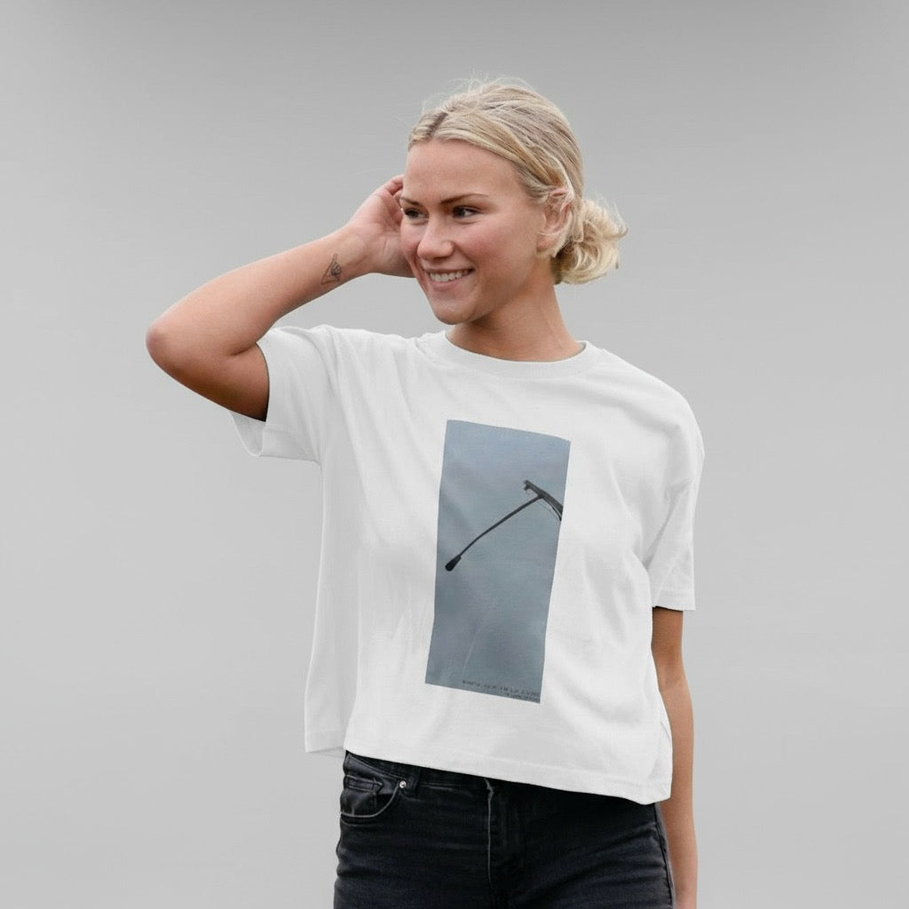 Person wearing a white t-shirt with a graphic design on a gray background