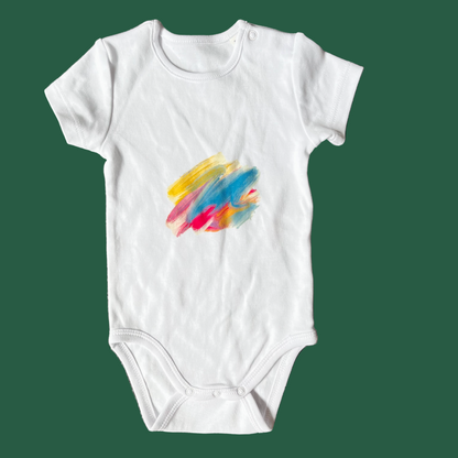 White baby onesie with colorful paint brush strokes printed on chest
