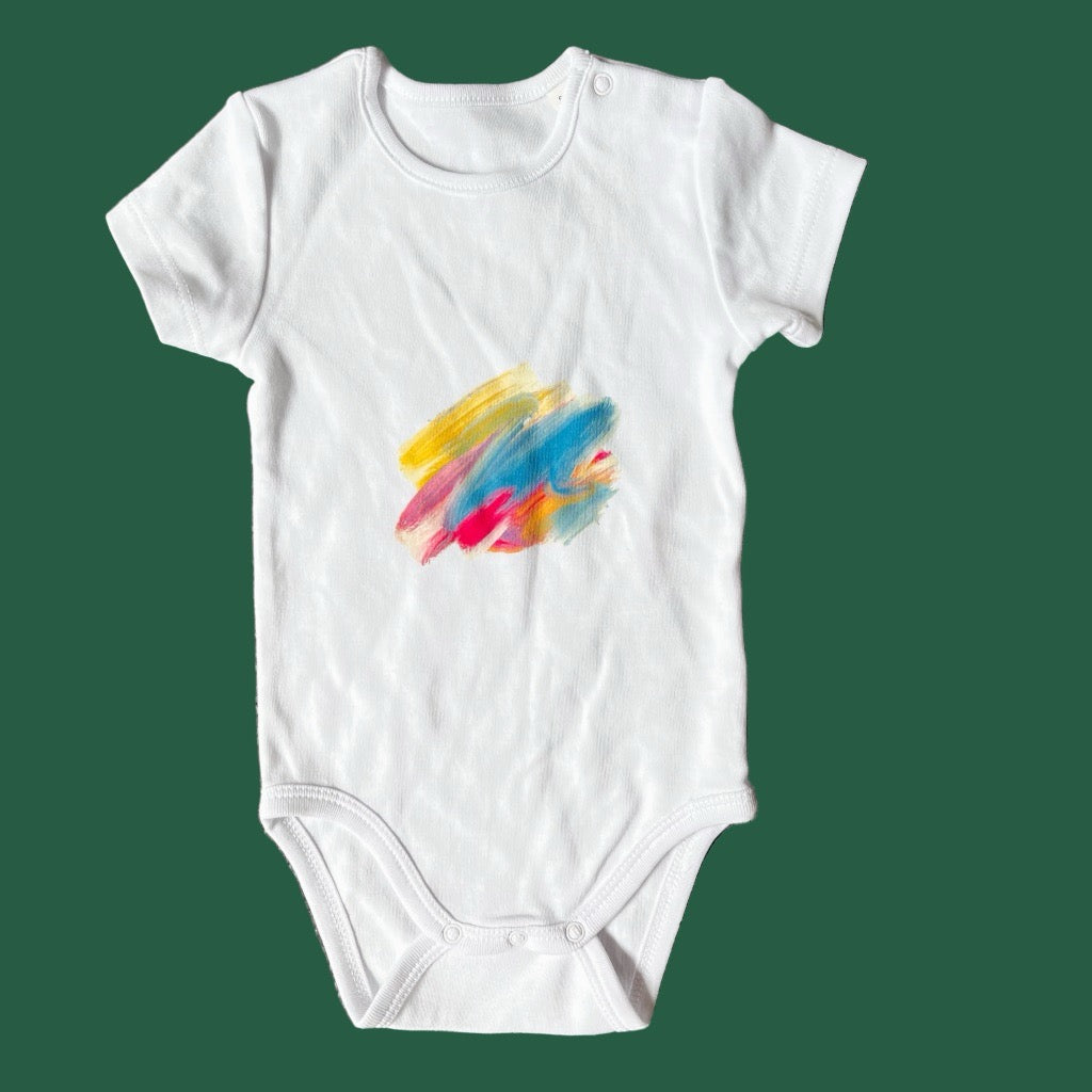 White baby onesie with colorful abstract design