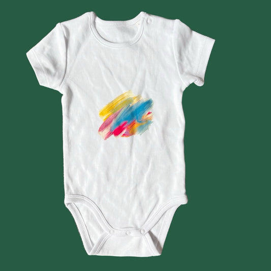 White baby onesie with colorful abstract design