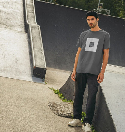 Man wearing a gray t-shirt with a white square design in an urban setting