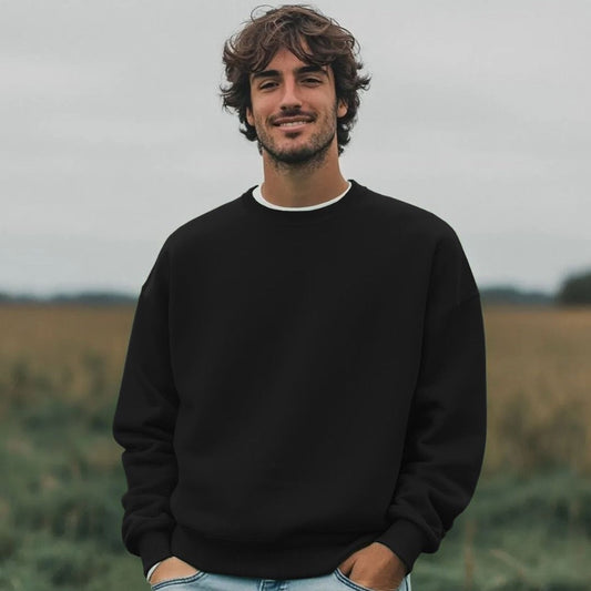 Man wearing a black sweatshirt standing in a field