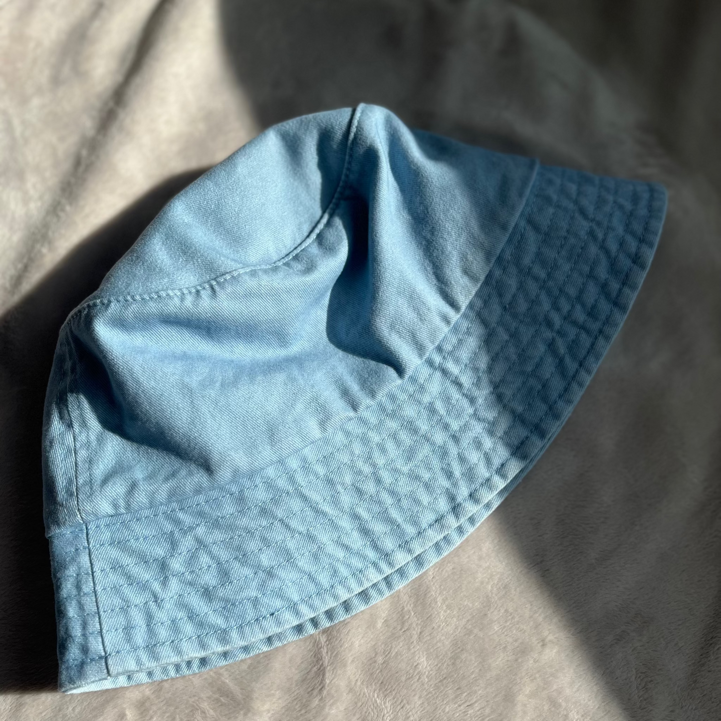 washed blue bucket hat flat lay product photo