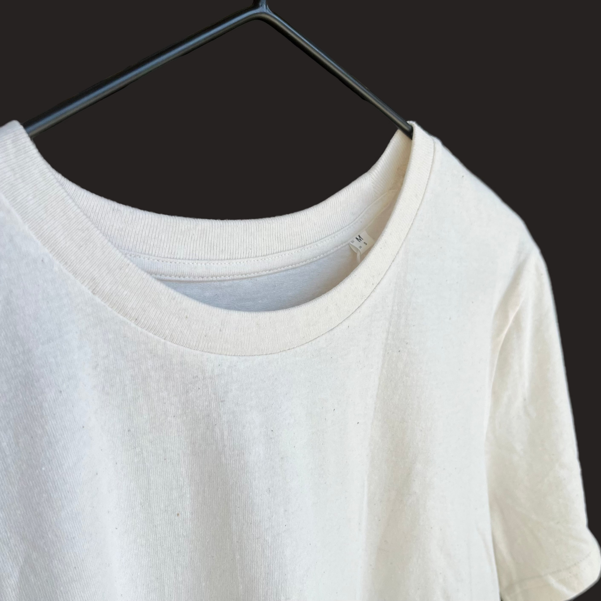White t-shirt on a hanger with a blurred background
