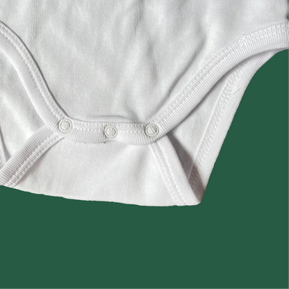 Close-up of a white baby bodysuit with buttons