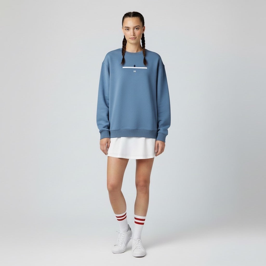 Person wearing a blue sweatshirt with a white logo on a plain background