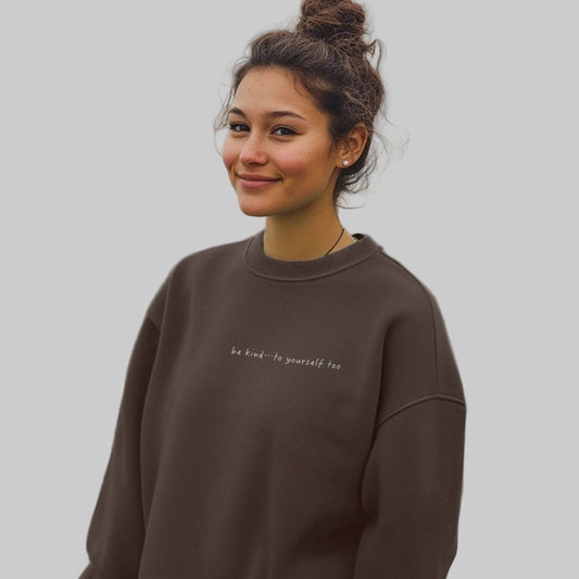 Female model wearing a chocolate brown sweatshirt with text printed on the chest
